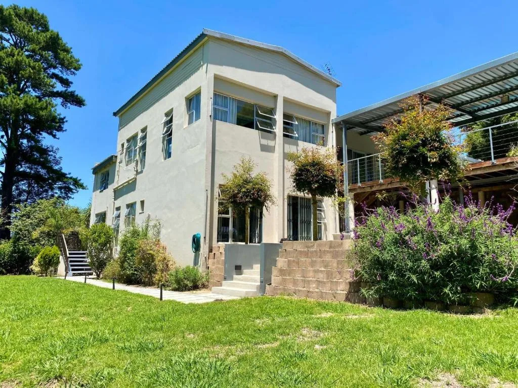 Modern white two-storey house with landscaped gardens and spacious lawn