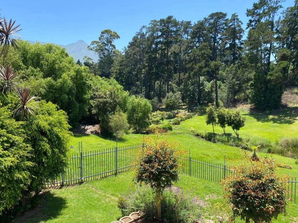 Mountain vista framed by manicured gardens and forest backdrop