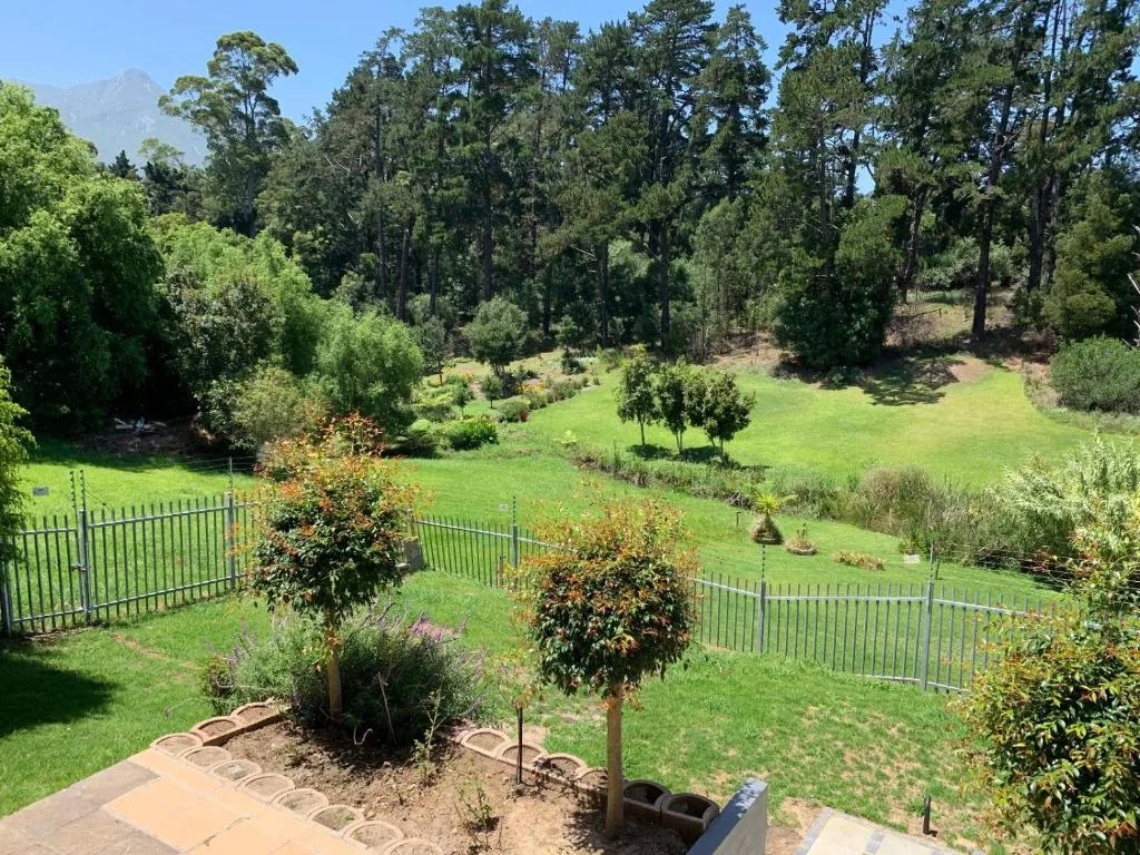 Lush green gardens with indigenous trees and mountain backdrop