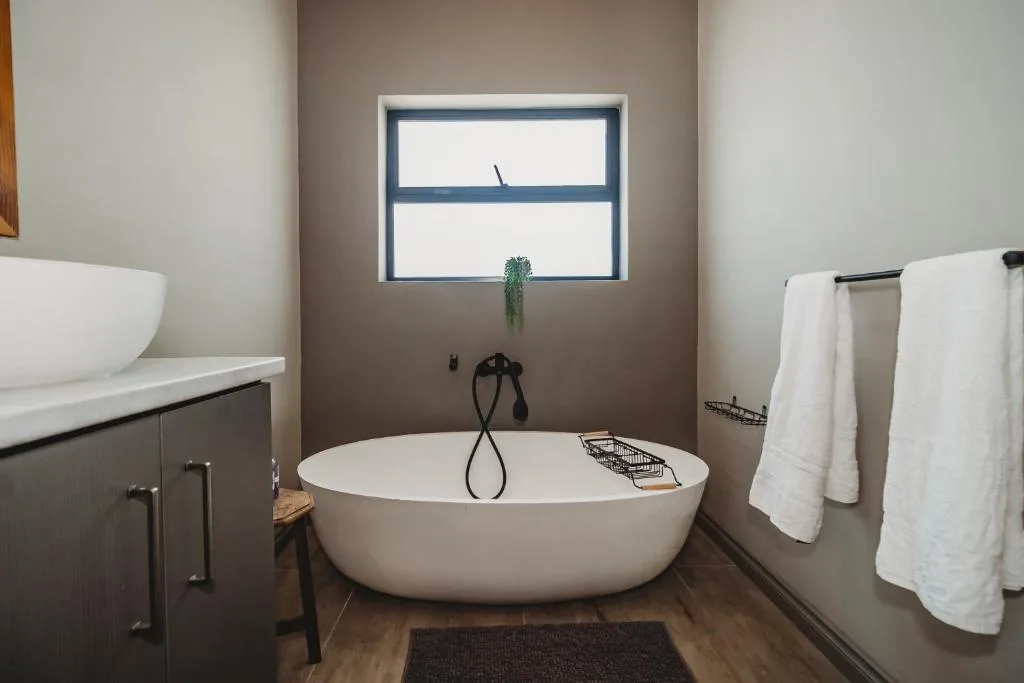 Modern bathroom with freestanding white oval bathtub and dual vanities