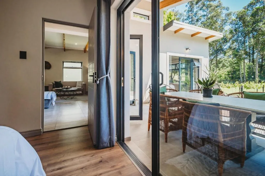 Modern outdoor deck with dining table and forest views, accessed via sliding doors