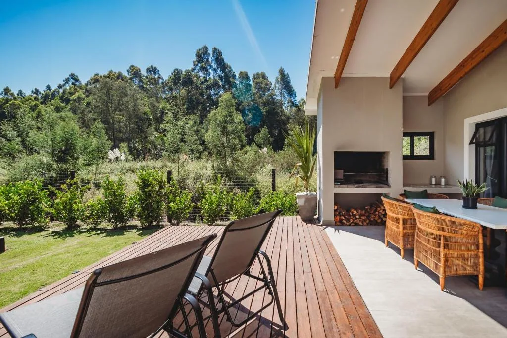Wooden deck with lounge chairs overlooking forested garden views