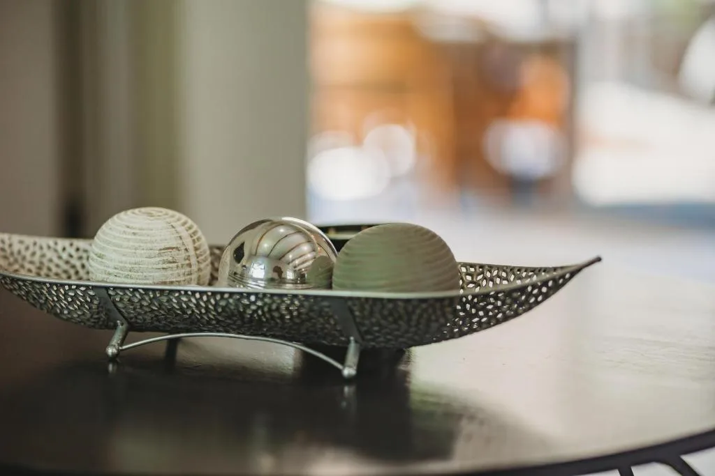Decorative metal bowl with ornamental spheres on table