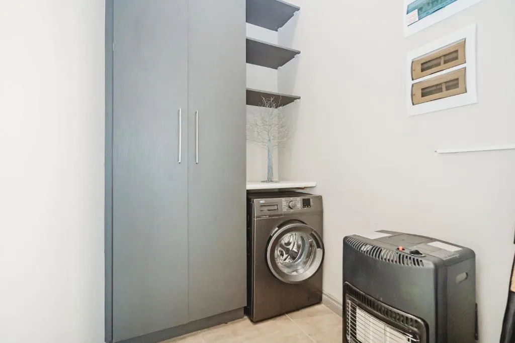 Modern laundry room with washing machine and storage cabinetry