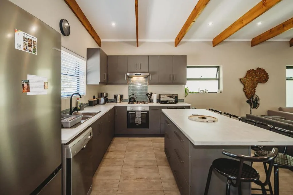 Modern kitchen with dark cabinetry, stainless steel appliances, and white countertops