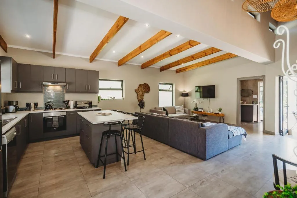 Open-plan living space with kitchen, dining island, and comfortable lounge seating