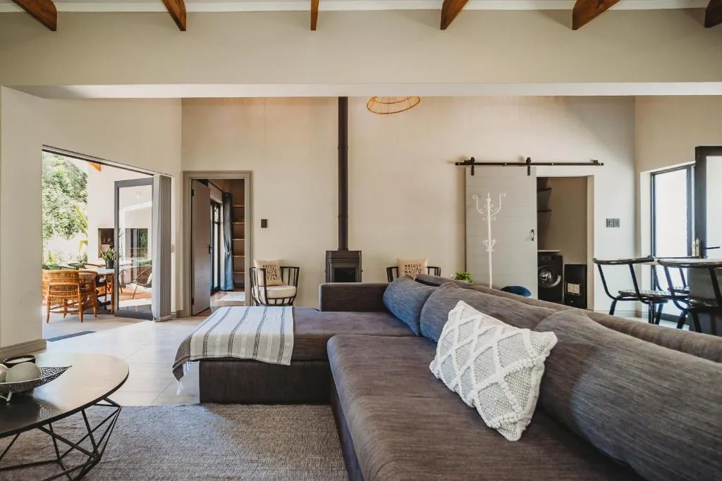 Open-plan lounge with dark sofa, fireplace, and access to outdoor deck