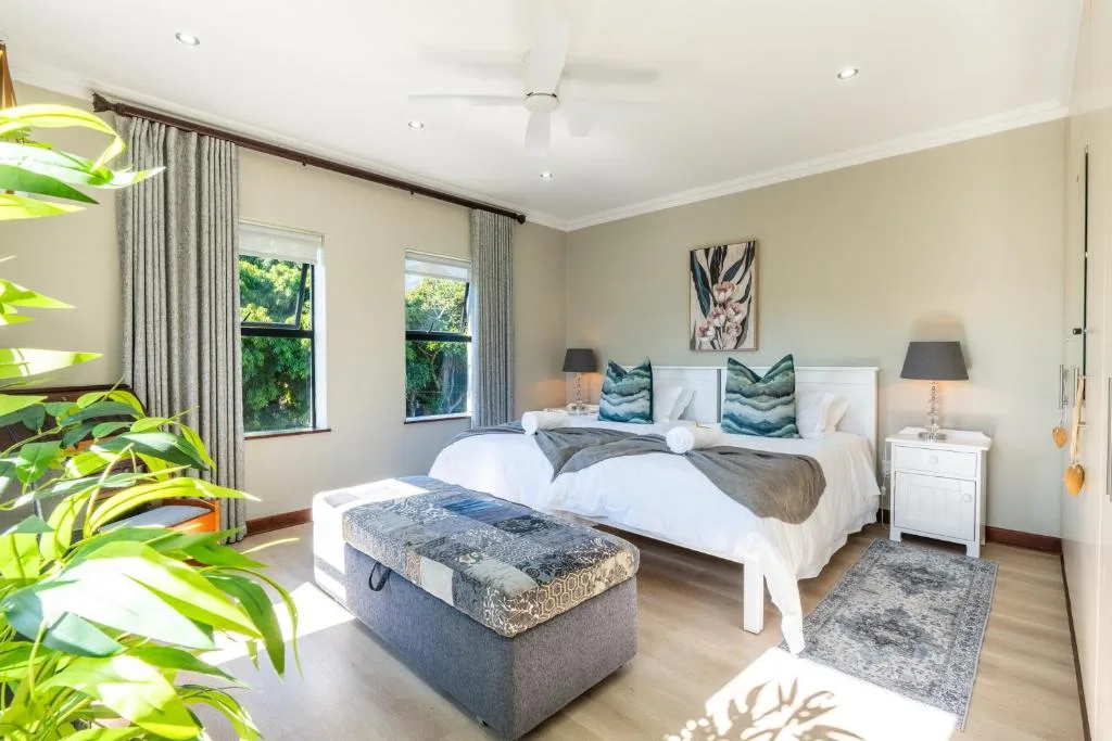 Bright bedroom with twin beds, white bedding, and green accent pillows
