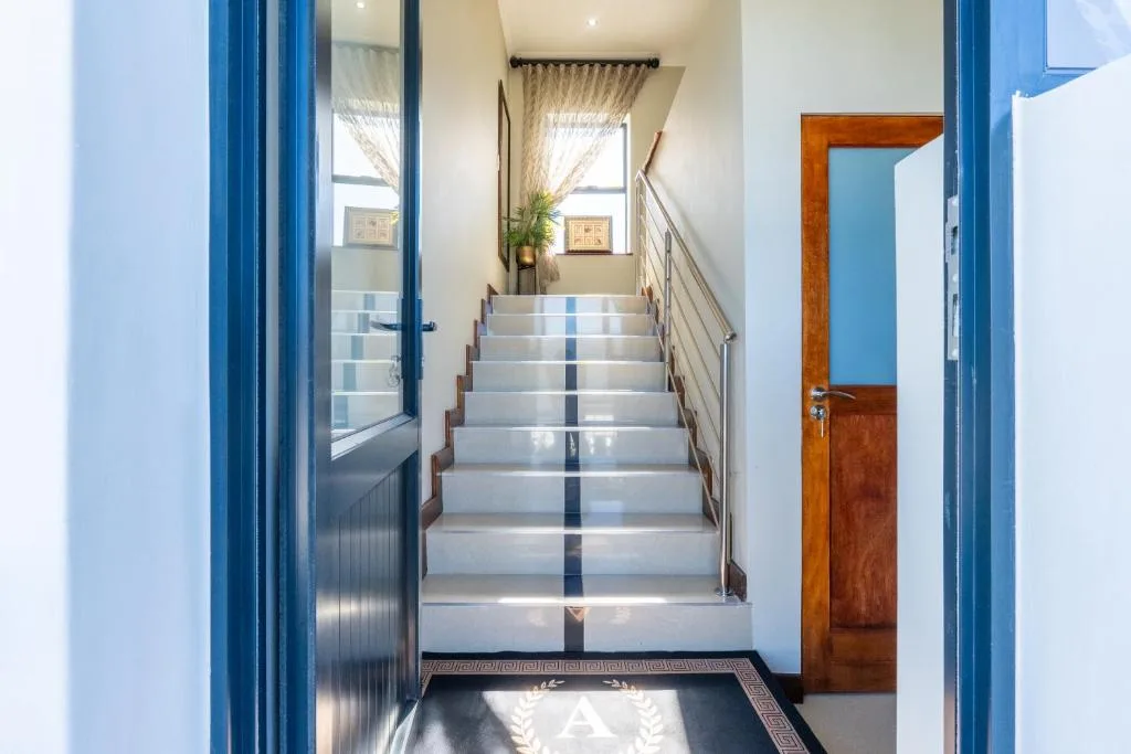Modern interior staircase with light gray steps and metal railing leading upward
