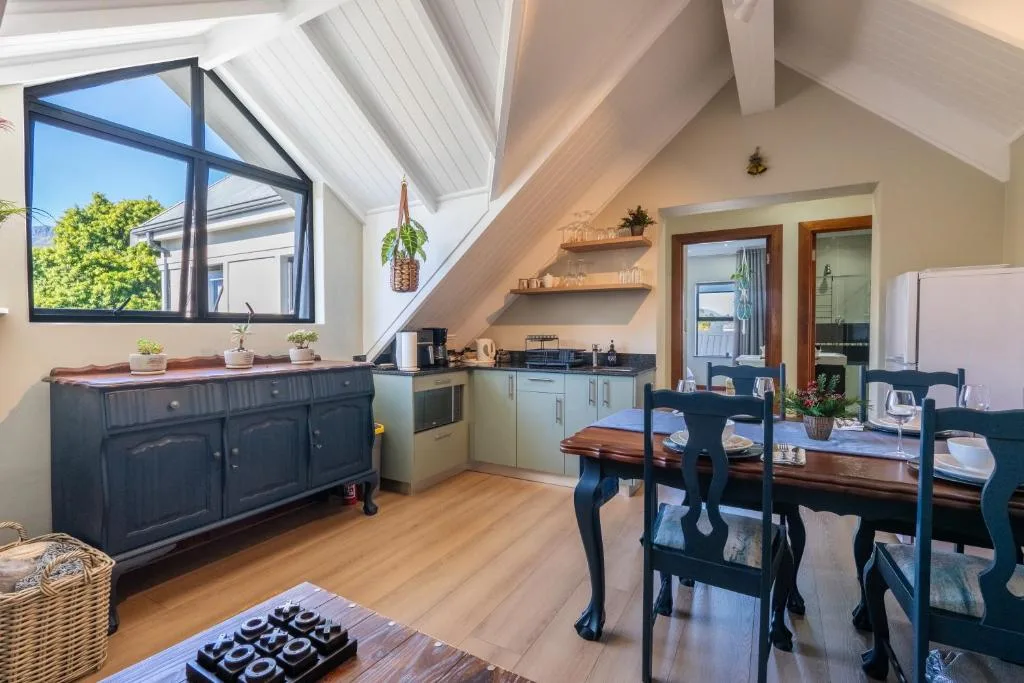 Open-plan kitchen and dining area with dark cabinetry and wooden table