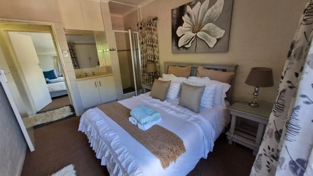 Spacious bedroom with queen bed, en-suite bathroom, and modern decor