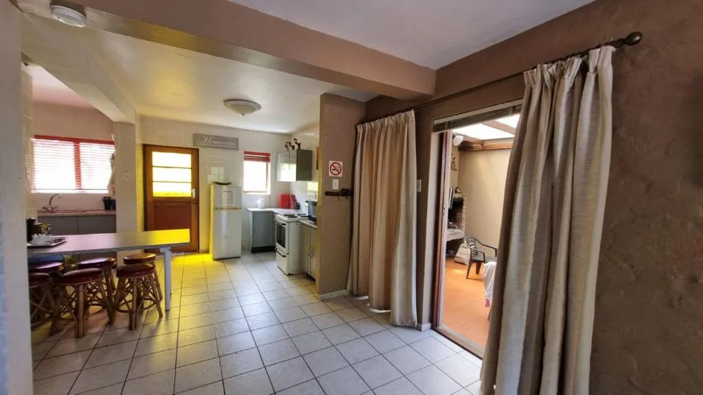 Open-plan kitchen with stove, fridge, and dining area visible
