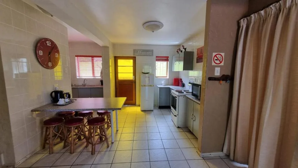 Bright kitchen with yellow accents, stove, refrigerator, and bar seating
