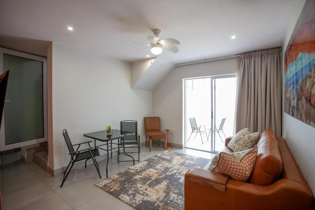 Spacious open-plan lounge with cognac leather sofa and dining area