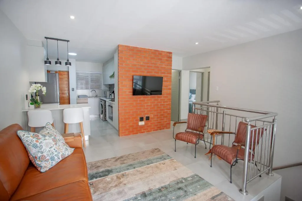 Modern open-plan lounge with orange accent wall and comfortable seating area