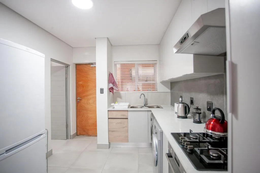 Modern kitchen with gas stove, white cabinetry, and stainless steel appliances