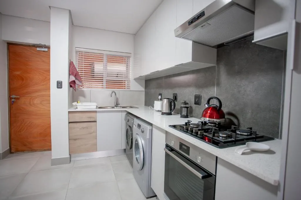 Modern kitchen with gas stove, oven, and washing machine appliances