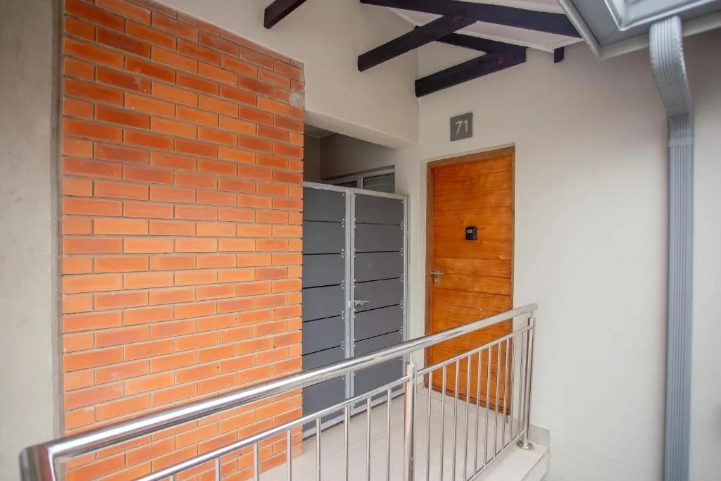 Modern apartment entrance with orange brick and wooden door