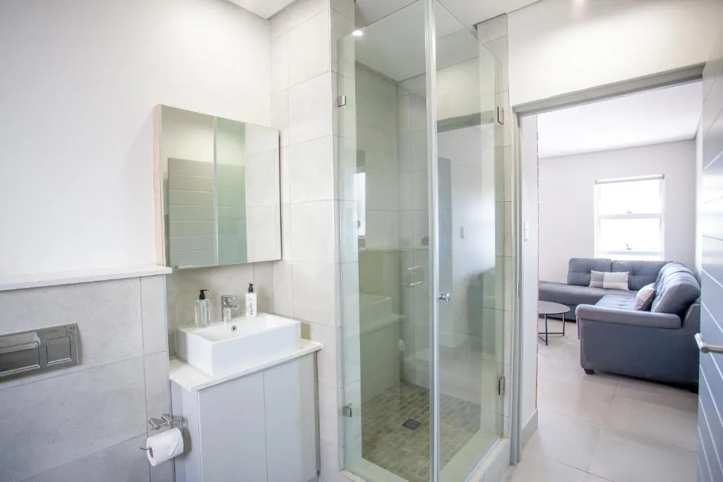 Modern bathroom with walk-in shower, vanity, and mirrored cabinet