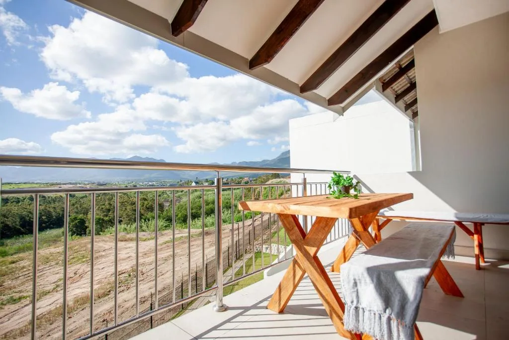 Spacious covered deck with wooden table overlooking scenic valley landscape