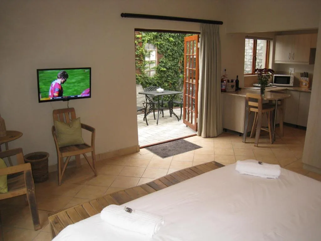 Spacious bedroom with twin beds, TV, and open glass doors to deck