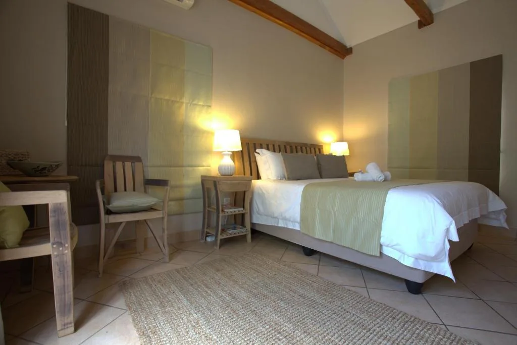 Spacious bedroom with double bed, wooden beams, and contemporary lighting fixtures