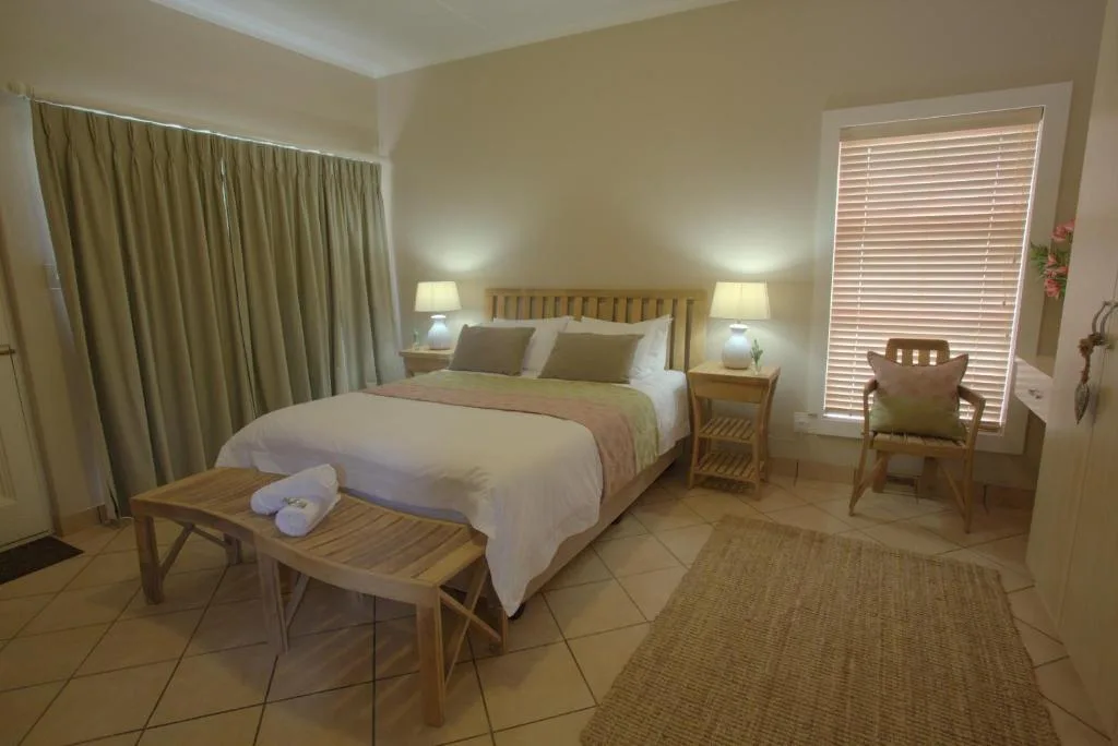 Spacious bedroom with queen bed, bedside lamps, and wooden furniture