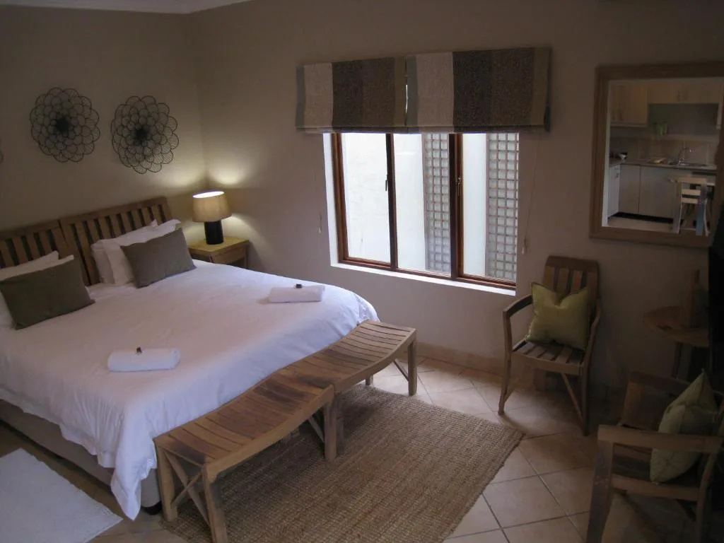 Spacious bedroom with queen bed, modern furnishings, and natural light