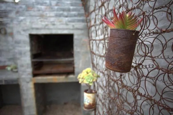 Hanging succulent plant in rustic metal pot on patterned wall