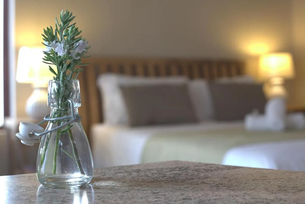 Fresh flowers in glass vase on bedroom surface