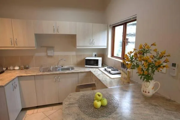 Modern kitchen with white cabinetry, granite countertop, and fresh flowers