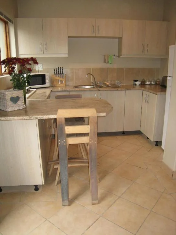 Modern kitchen with cream cabinetry, granite countertop, and wooden bar seating