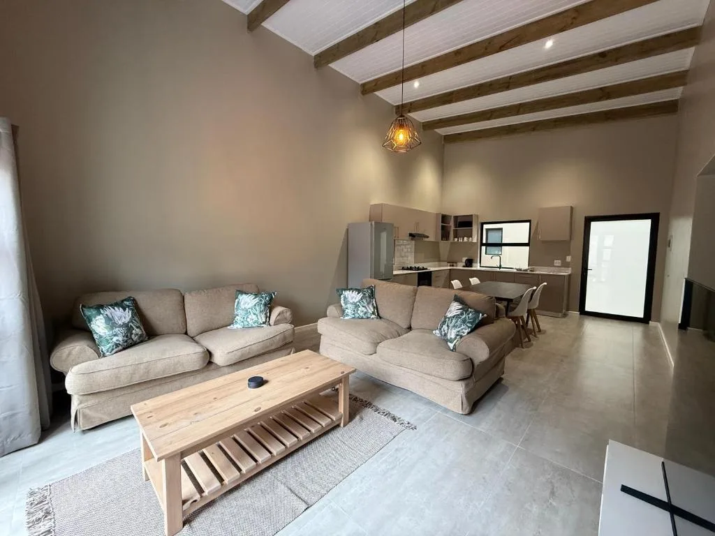 Spacious open-plan lounge with cream sofas and wooden coffee table