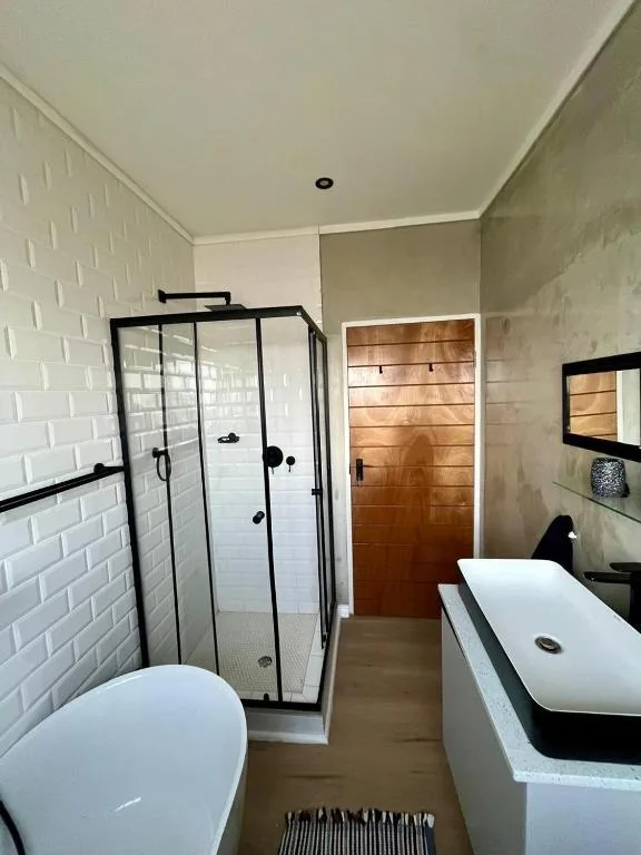 Modern bathroom with walk-in shower, freestanding tub, and wooden accents
