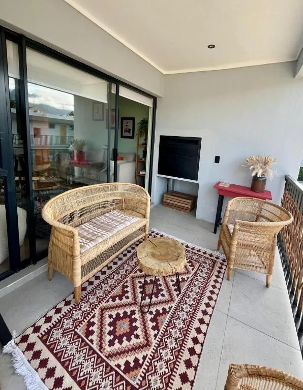 Wicker seating area with patterned rug and sliding glass doors