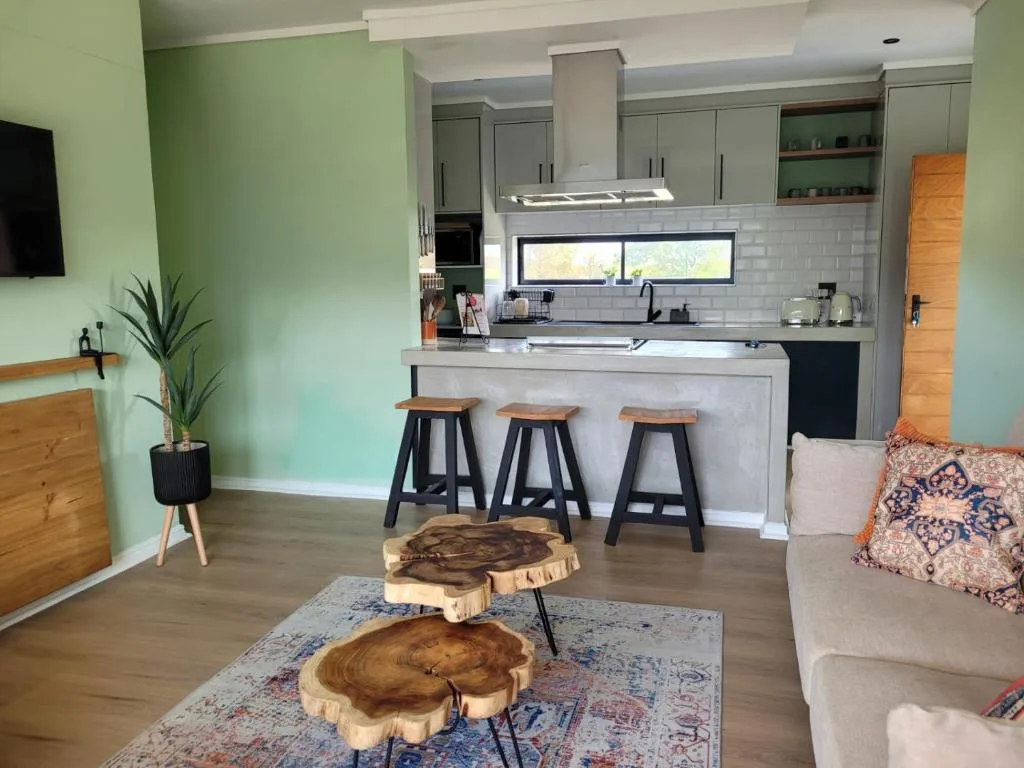 Open-plan lounge and kitchen with sofa, wooden coffee table, bar seating