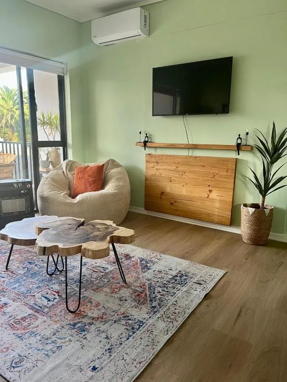Modern living room with cream armchair, wooden coffee table, wall-mounted TV