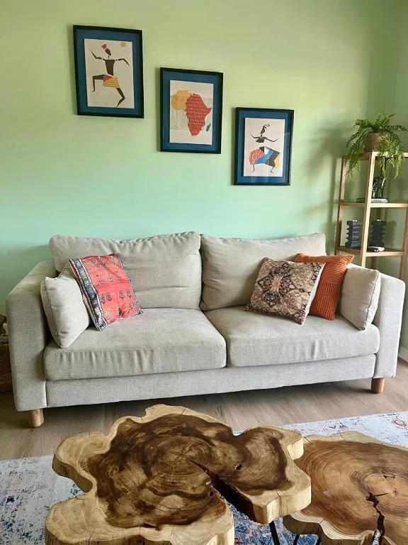 Light gray sofa with colorful cushions in bright green living room