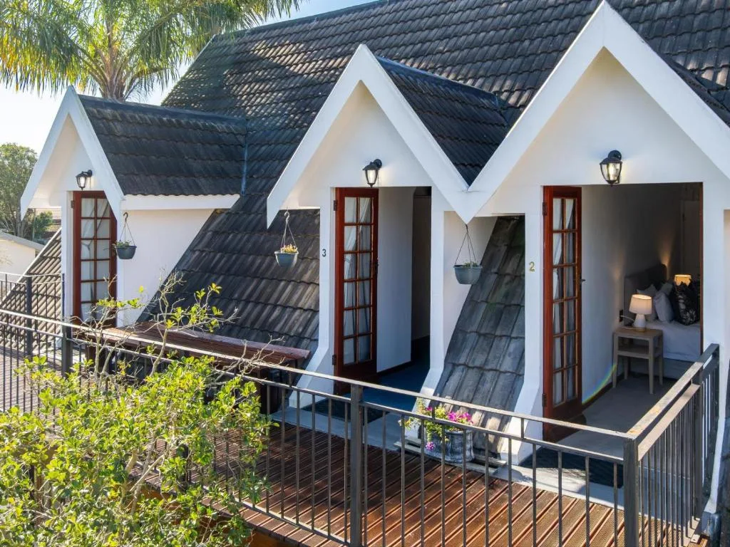 White cottages with dark roofs and red doors, wooden deck and railing