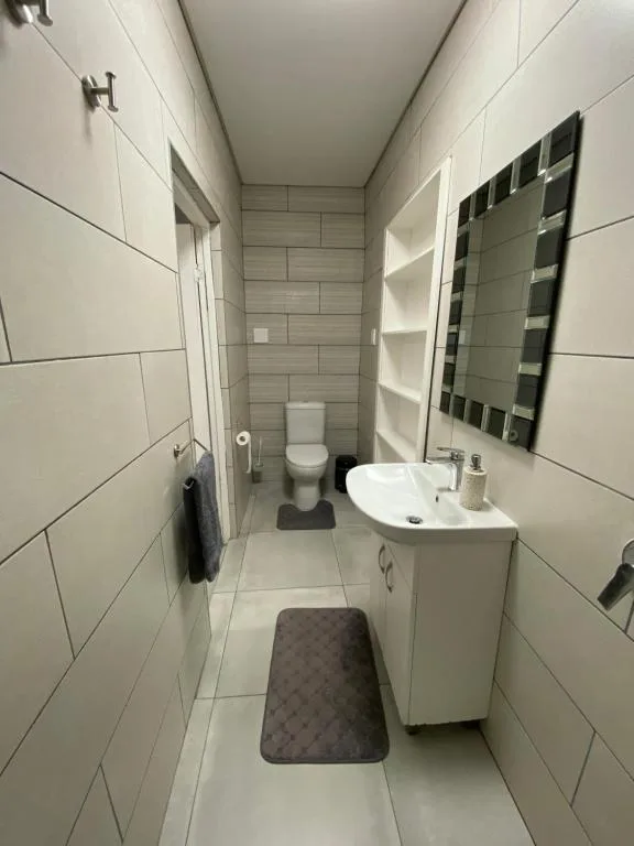 Modern bathroom with white subway tiles, sink, toilet, and mirror