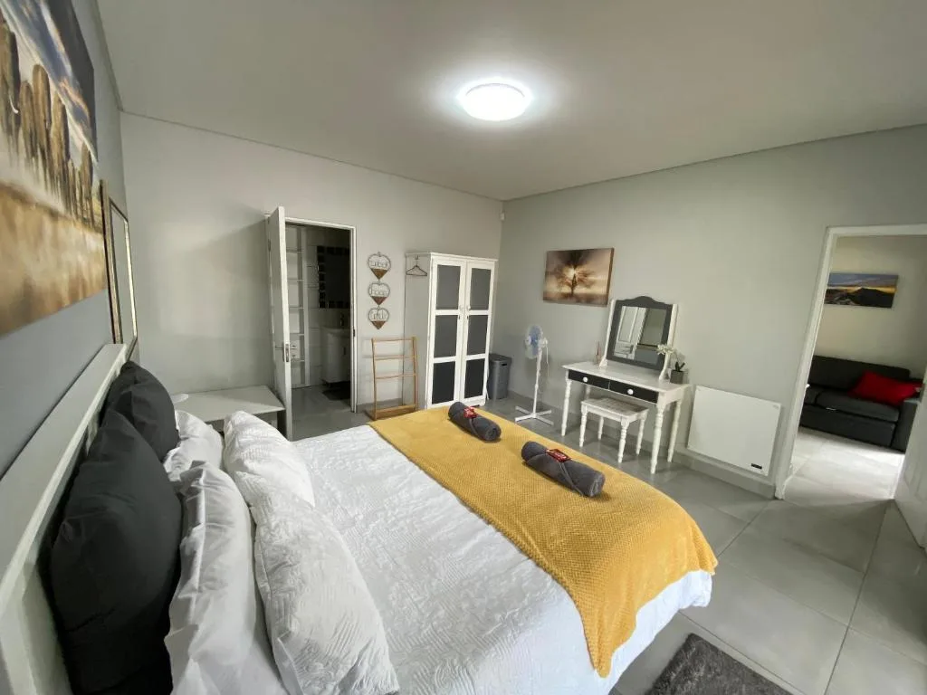 Spacious bedroom with double bed, vanity desk, and modern amenities