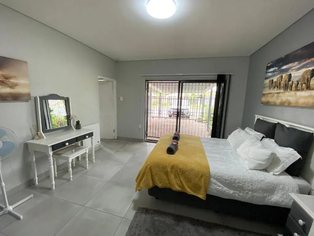 Spacious bedroom with queen bed, vanity desk, and glass doors to patio