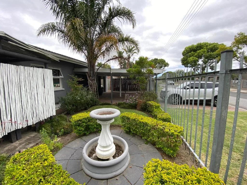 Front garden with decorative bird bath and manicured shrubs