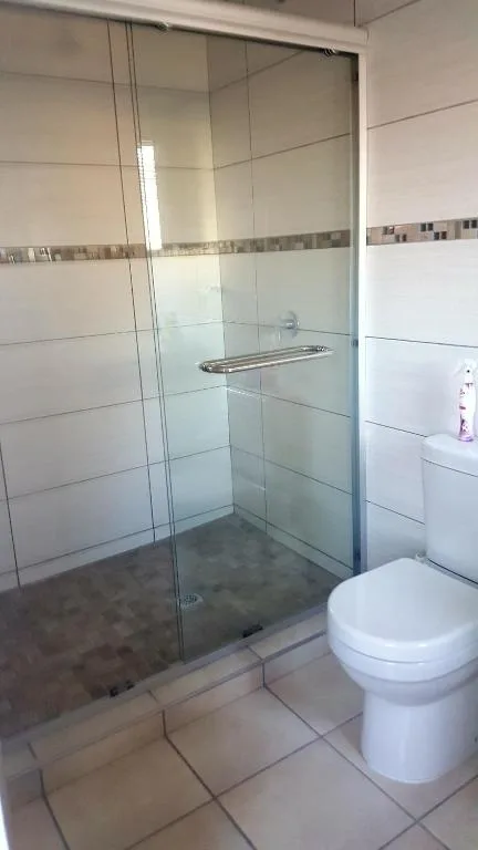 Modern bathroom with glass shower enclosure and white toilet