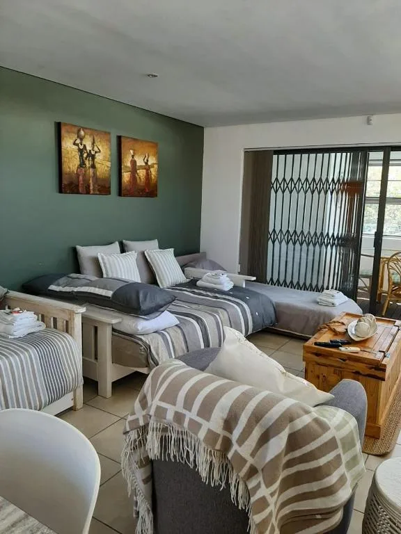 Spacious bedroom with multiple beds, green accent wall, and patio doors
