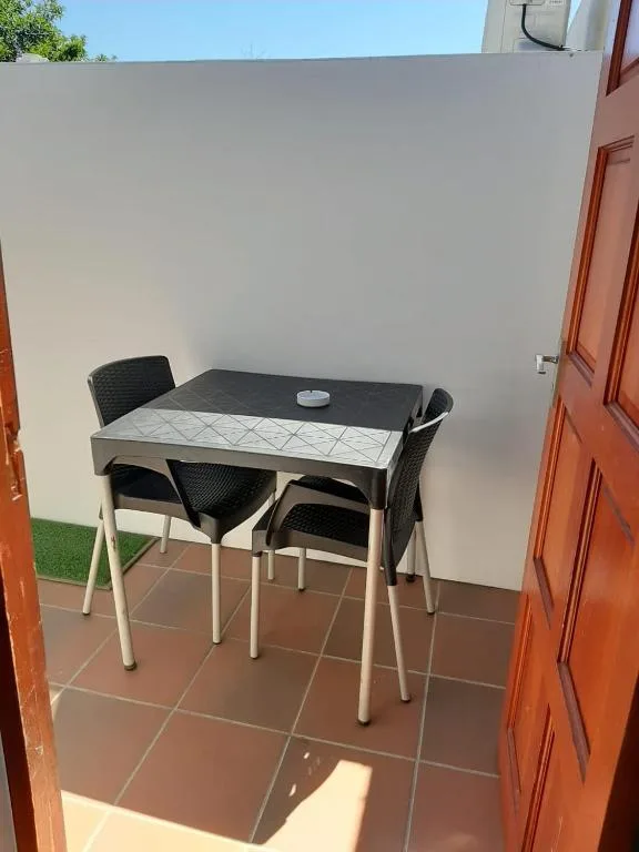 Outdoor patio with small dining table and two black chairs