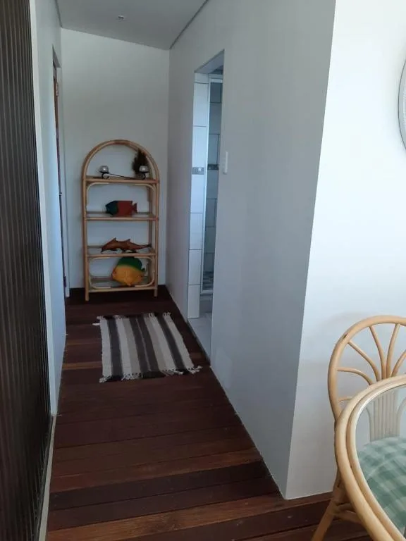 Hallway with wooden shelving unit and striped runner rug
