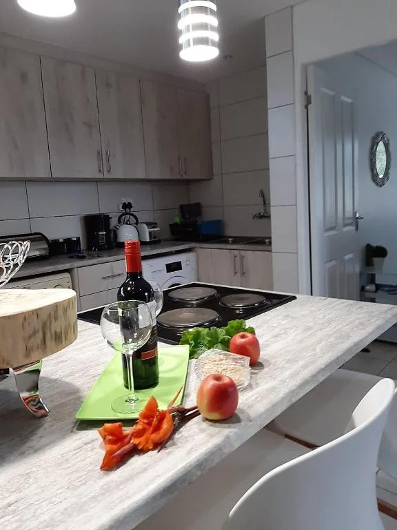 Modern kitchen with marble countertop, white cabinetry, and fresh produce displayed