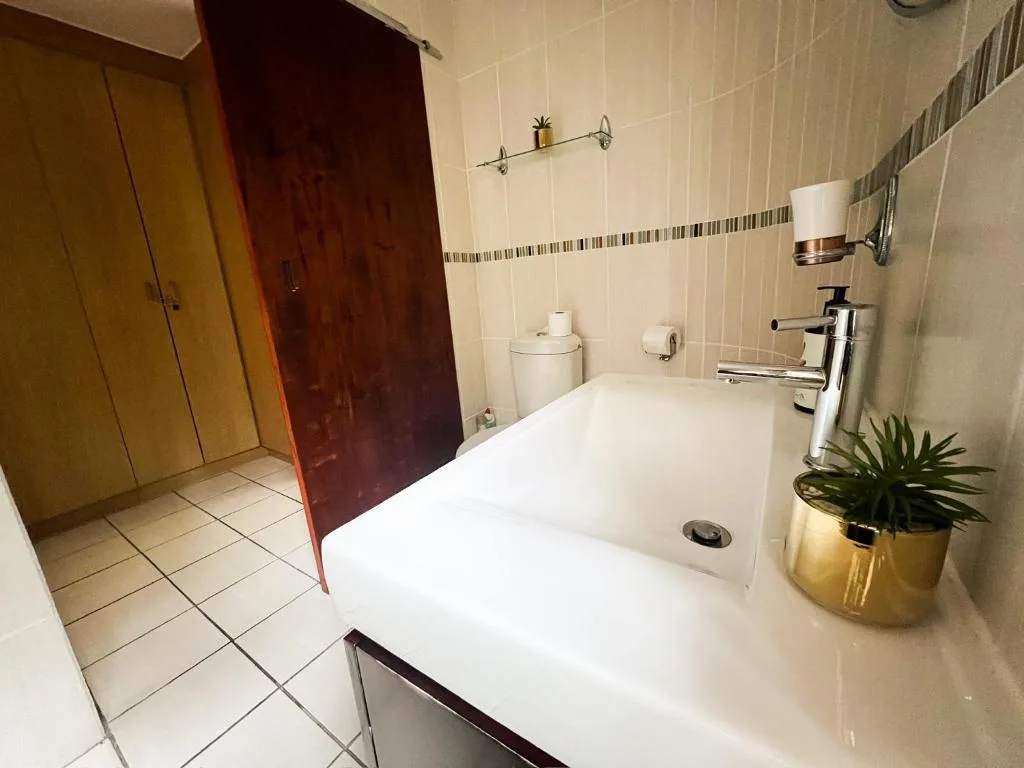 Modern bathroom with white bathtub, chrome faucet, and tiled walls