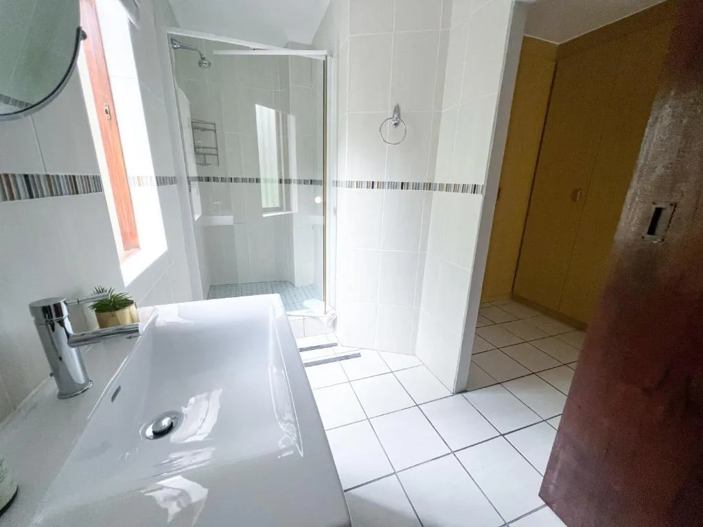 Modern bathroom with vanity sink, glass shower enclosure, and bright natural light